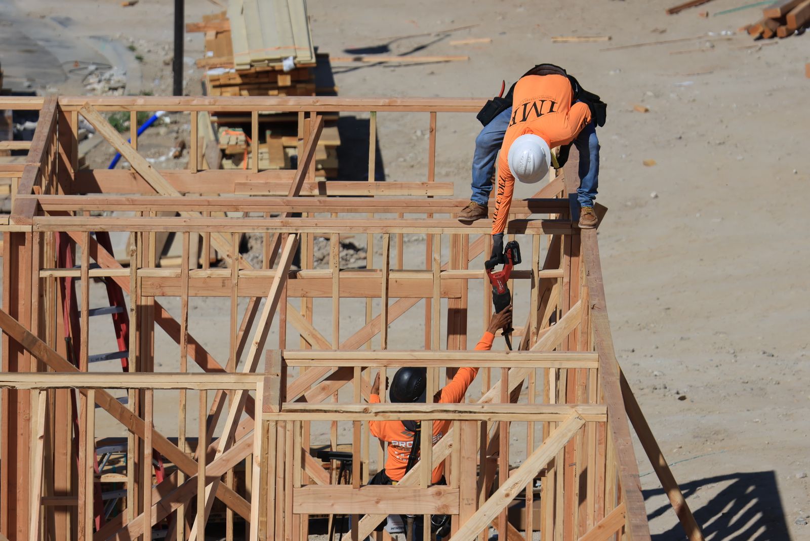 Framing crew working on the walls of a house on a residential job site